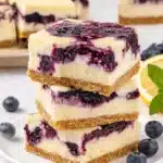 Delicious blueberry cheesecake bars topped with fresh blueberries and creamy filling.