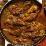 Plate of authentic Jamaican curry chicken with rice and vegetables