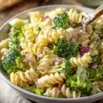 Colorful broccoli pasta salad in a bowl with vegetables and dressing