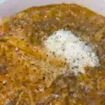 A bowl of delicious lasagna soup topped with herbs and cheese