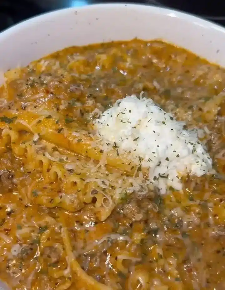 A bowl of delicious lasagna soup topped with herbs and cheese