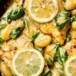 Creamy Lemon Chicken Gnocchi served in a bowl with fresh herbs and lemon slices