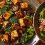 Colorful mushroom tofu stir-fry with fresh vegetables in a pan.