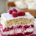 Slice of white chocolate raspberry tiramisu with fresh raspberries on top