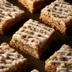 Delicious iced oatmeal cookie bars drizzled with icing on a plate