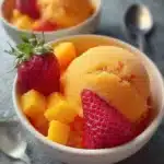 Delicious Mango Strawberry Sorbet served in a bowl with fresh fruit garnish