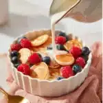 Delicious pancake cereal served in a bowl with syrup and berries.