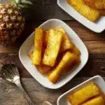 Roasted pineapple drizzled with honey cinnamon glaze on a serving plate