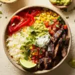 A colorful Steak Fajita Bowl with grilled steak, bell peppers, and onions.